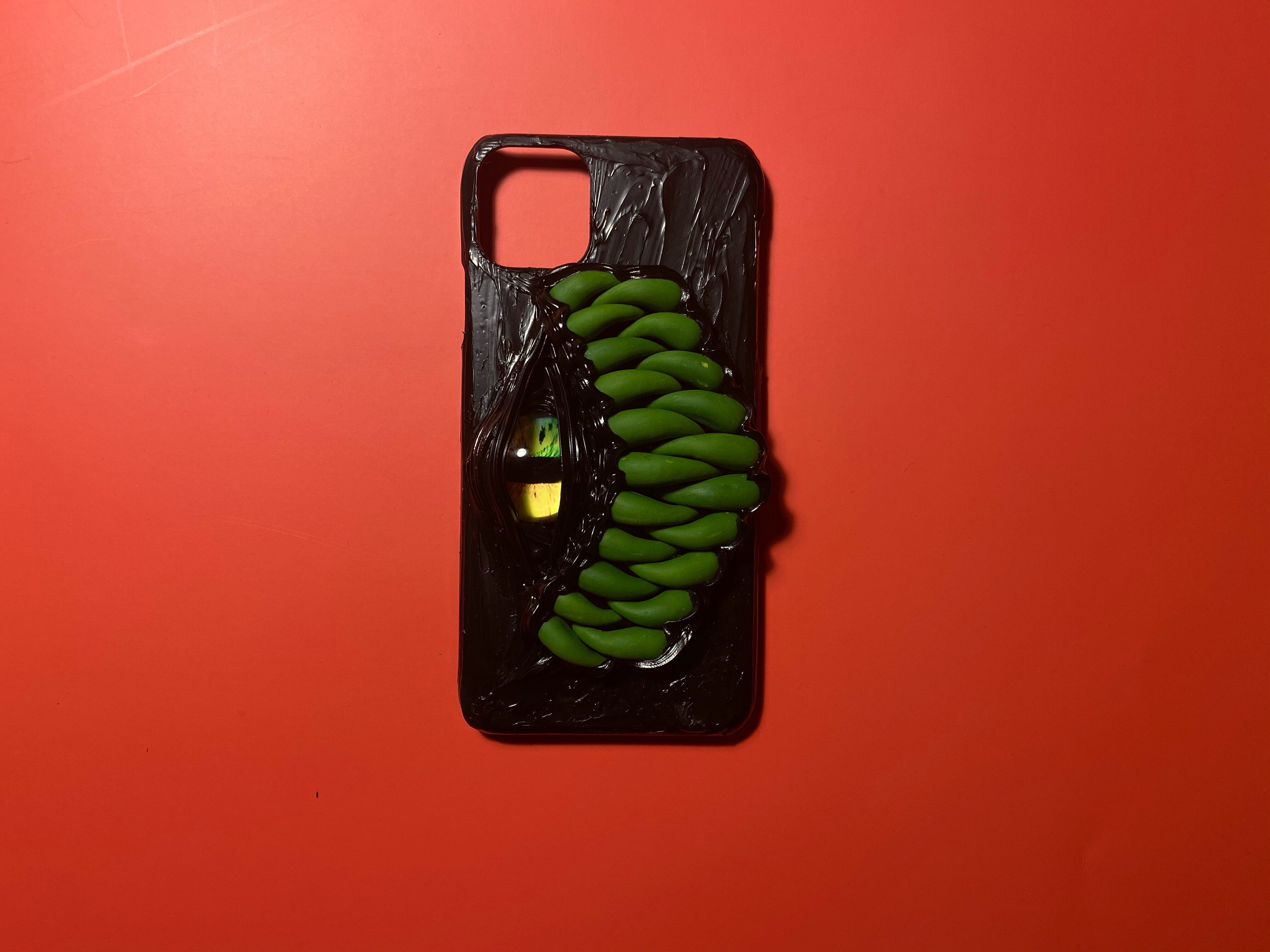 Handmade black iPhone case featuring a purple Cthulhu-inspired eye and textured monster scales.