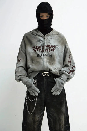 A person wearing a destruction-style loose zip-up hoodie with graphic prints.