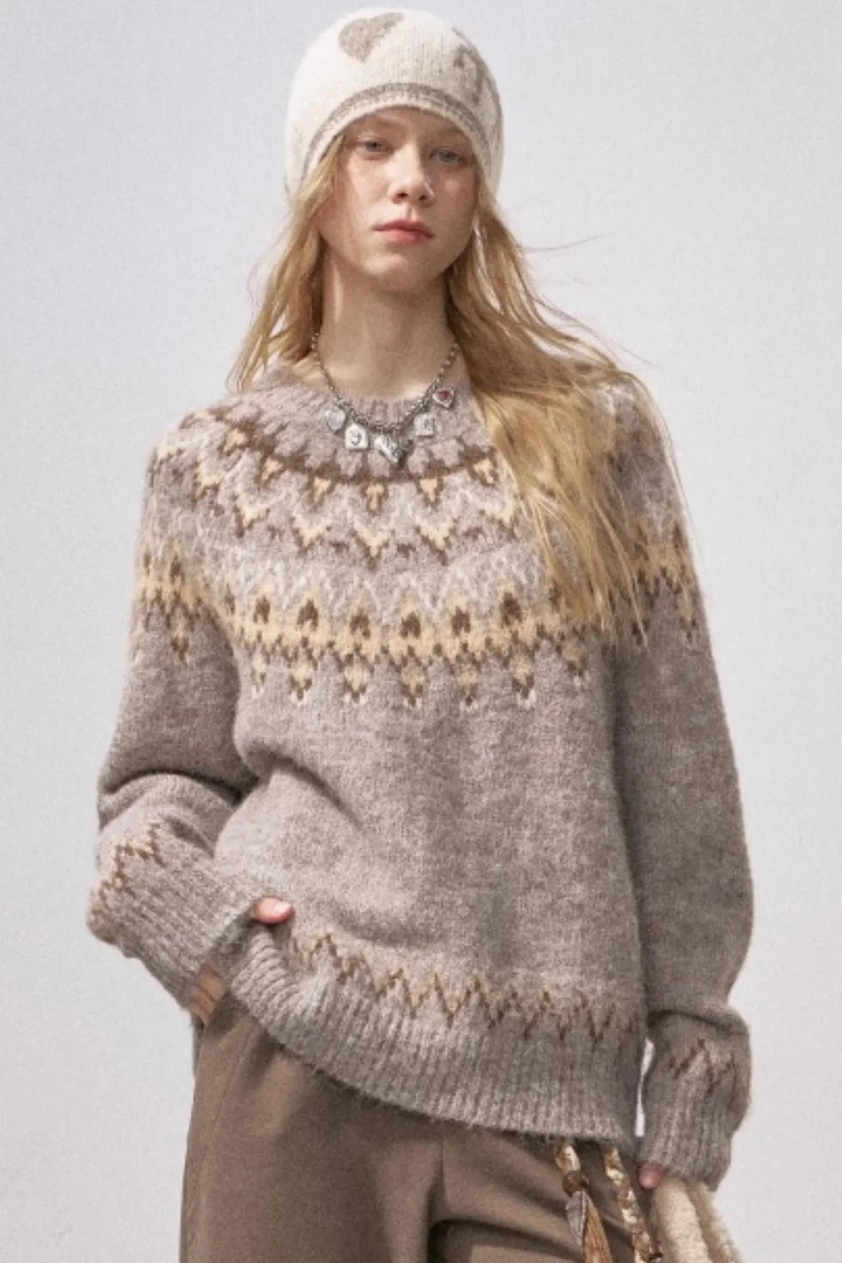 A woman wearing a festive Fair Isle patterned knit sweater.