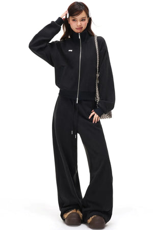 A black fleece zip-up jacket and matching pants set.