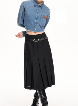 A model wearing a high-waisted black pleated skirt.