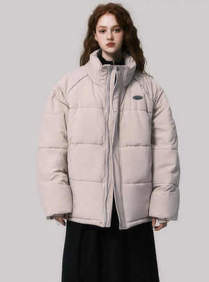 A model wearing a beige puffer jacket with a stand collar.