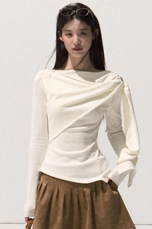 A white wrap-around knit sweater with elegant draping.