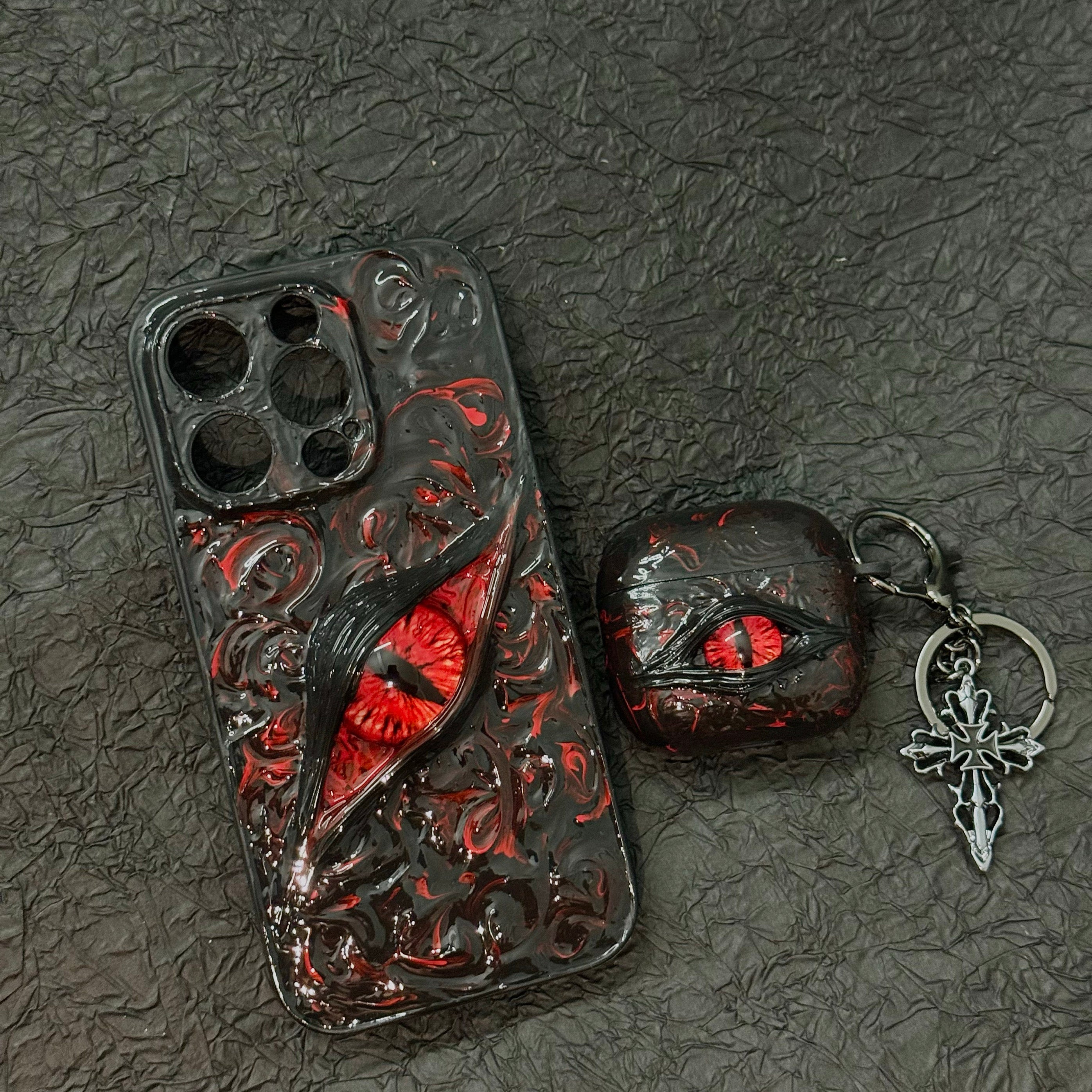 A white 3D textured AirPods case featuring a realistic glowing blue eye design with a star charm.