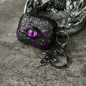 A white 3D textured AirPods case featuring a realistic glowing blue eye design with a star charm.