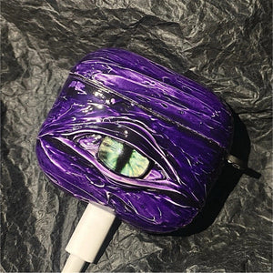 A white 3D textured AirPods case featuring a realistic glowing blue eye design with a star charm.