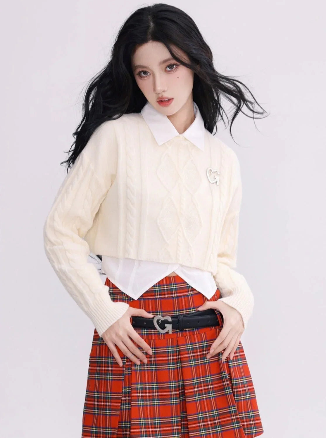 A model wearing a white cropped cable-knit sweater with a collar.