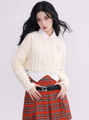 A model wearing a white cropped cable-knit sweater with a collar.