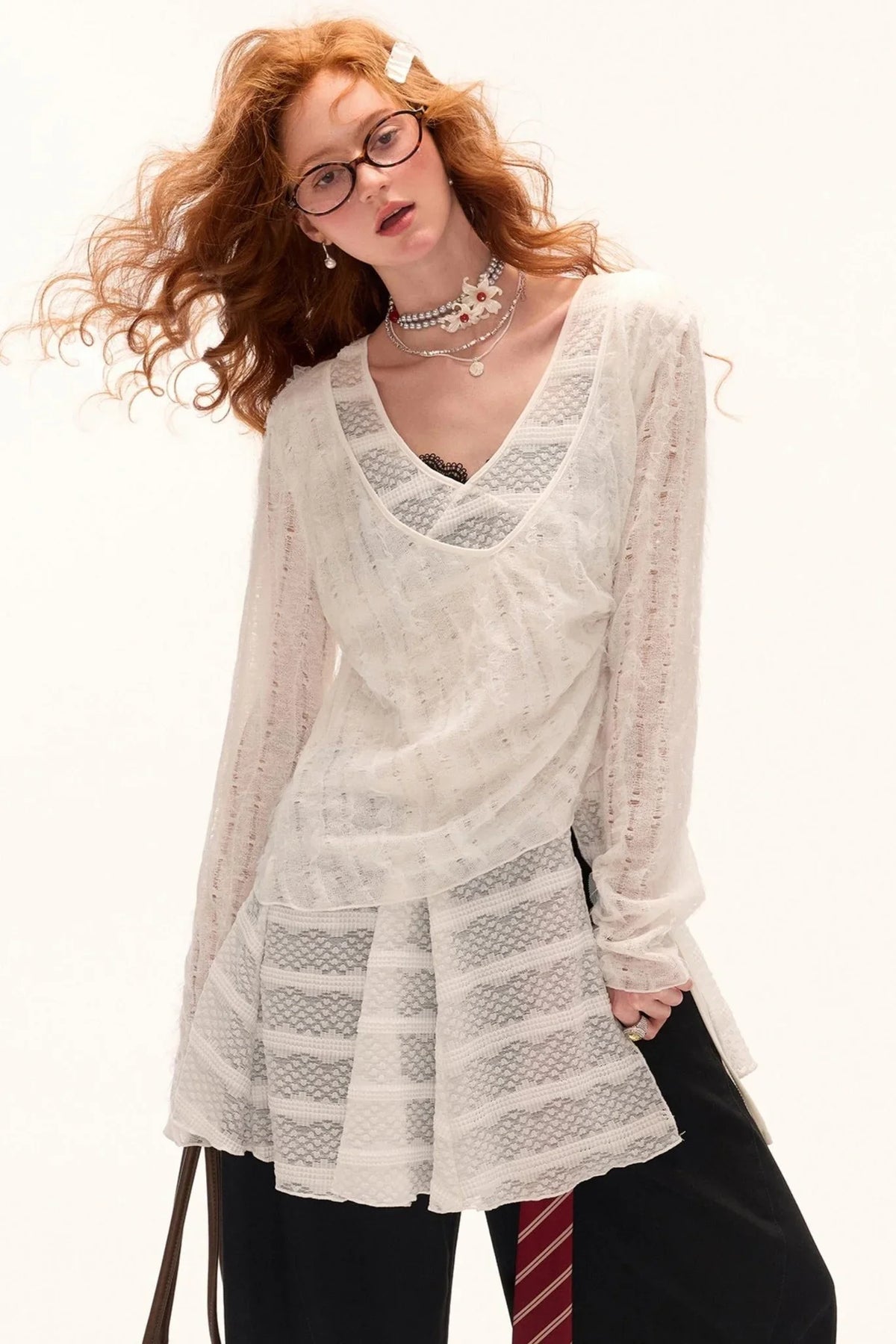 A woman wearing a white long-sleeved blouse.