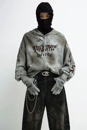 A person wearing a destruction-style loose zip-up hoodie with graphic prints.