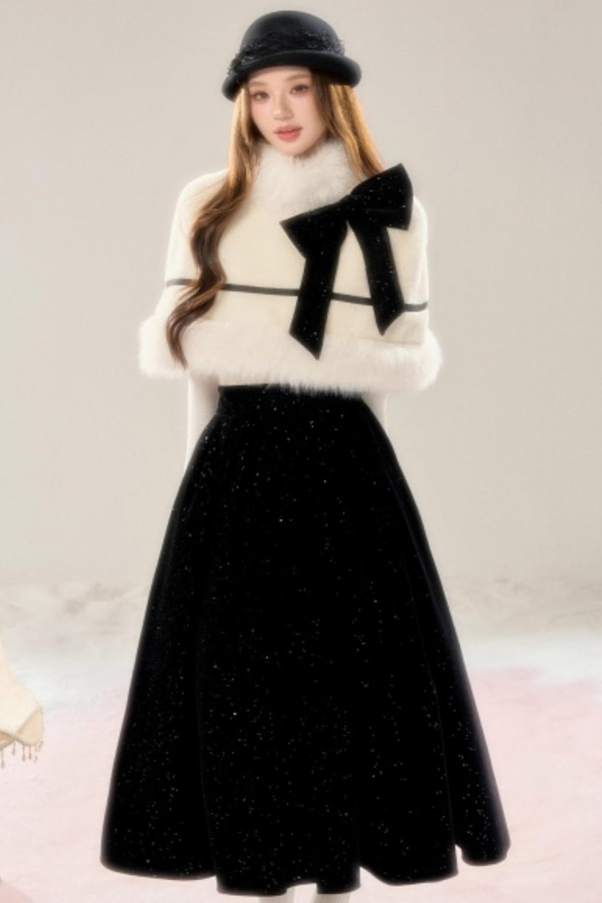 A woman wearing a beige faux-fur trimmed cloak and a black velvet skirt.
