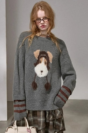 A woman wearing a gray knitted sweater with a puppy graphic.