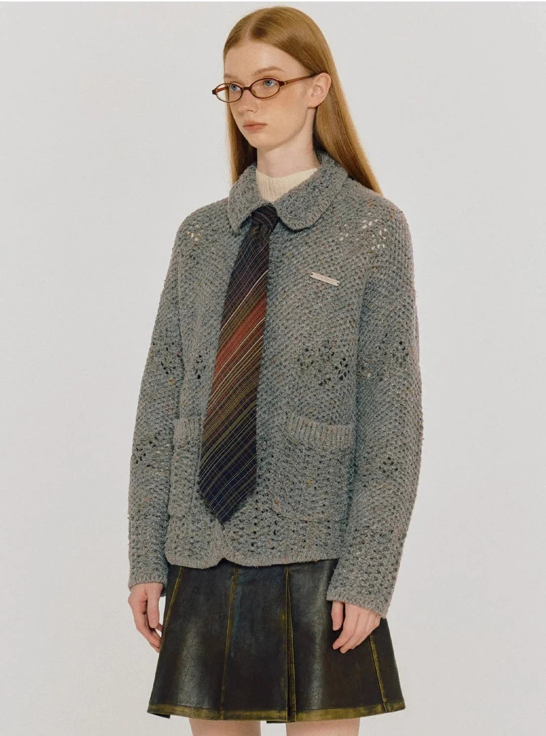 A woman wearing a gray thermal knitted cardigan jacket with a tie.
