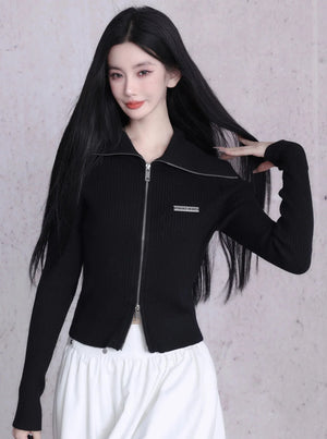 A black ribbed knit cardigan with a zipper closure and large lapels.