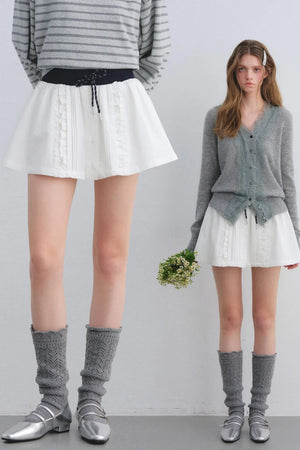 A white skirt with delicate lace trim and a patchwork design.