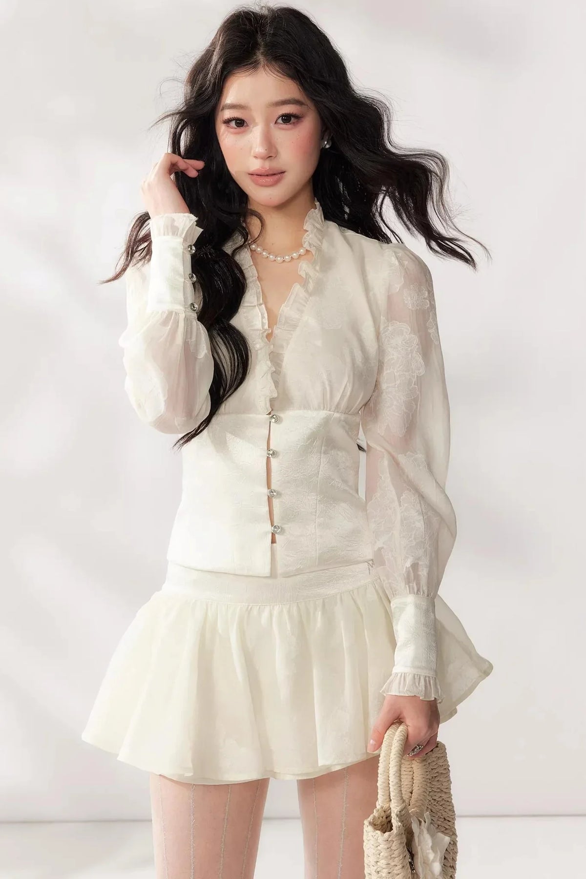 A white two-piece lace skirt set featuring a V-neck top and matching skirt.