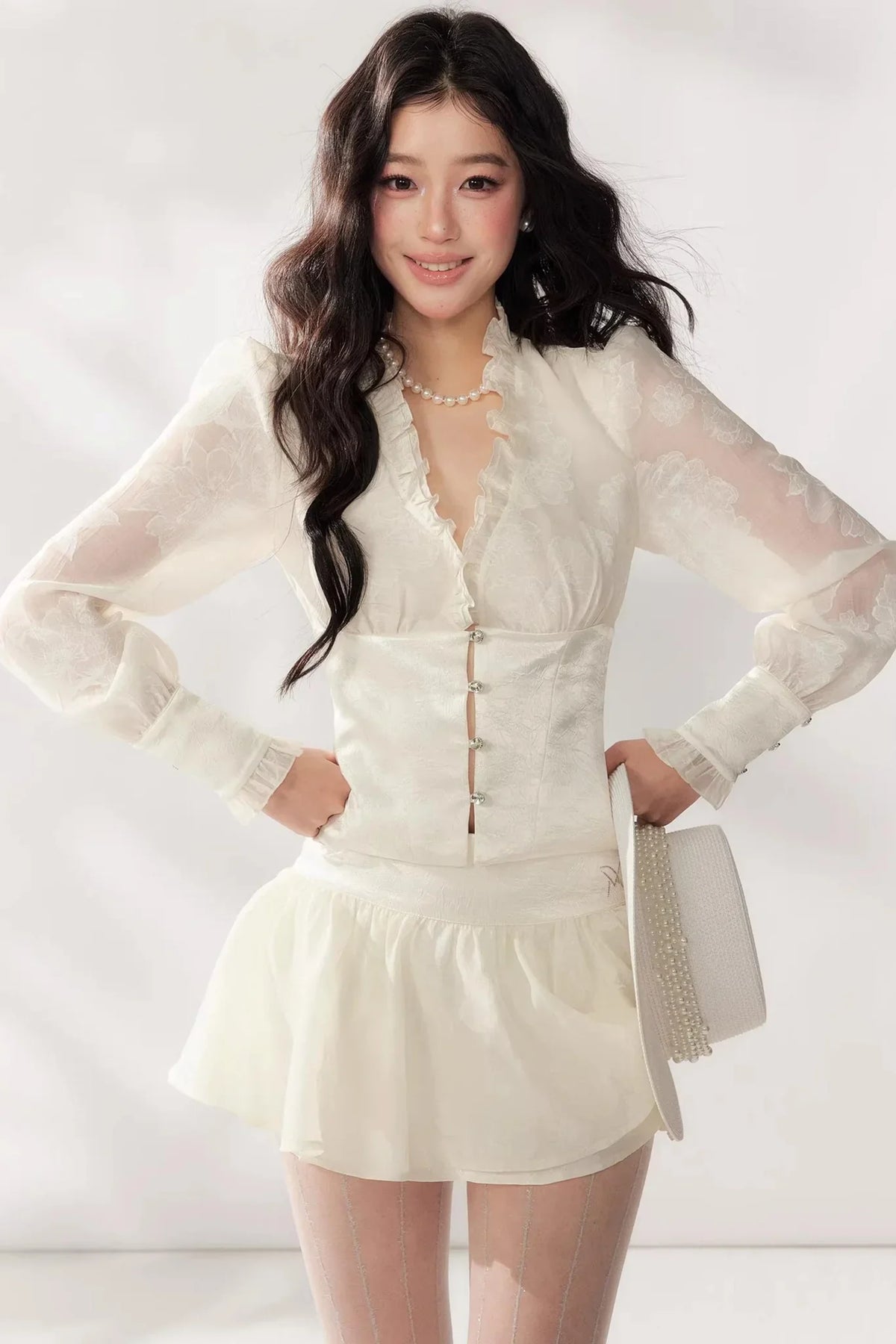 A white two-piece lace skirt set featuring a V-neck top and matching skirt.