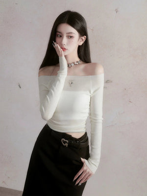 A woman wearing a long-sleeved white top with an off-shoulder neckline.