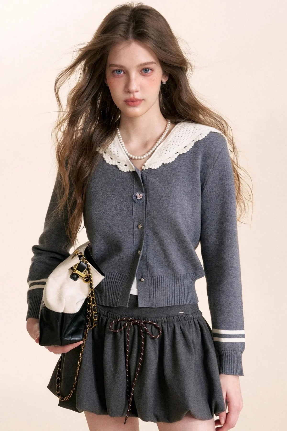 A gray knit cardigan with crochet lace detailing.