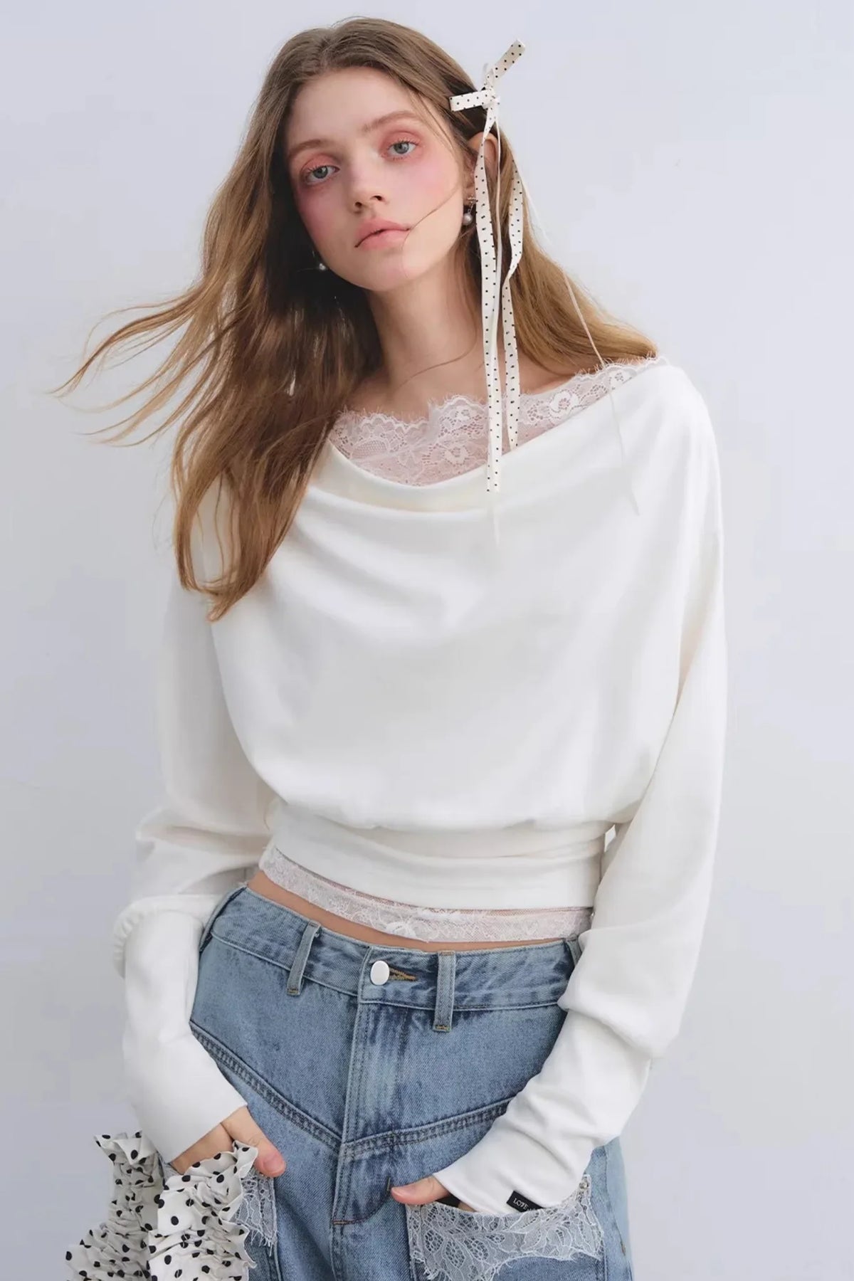 A white off-shoulder top with lace patchwork details.