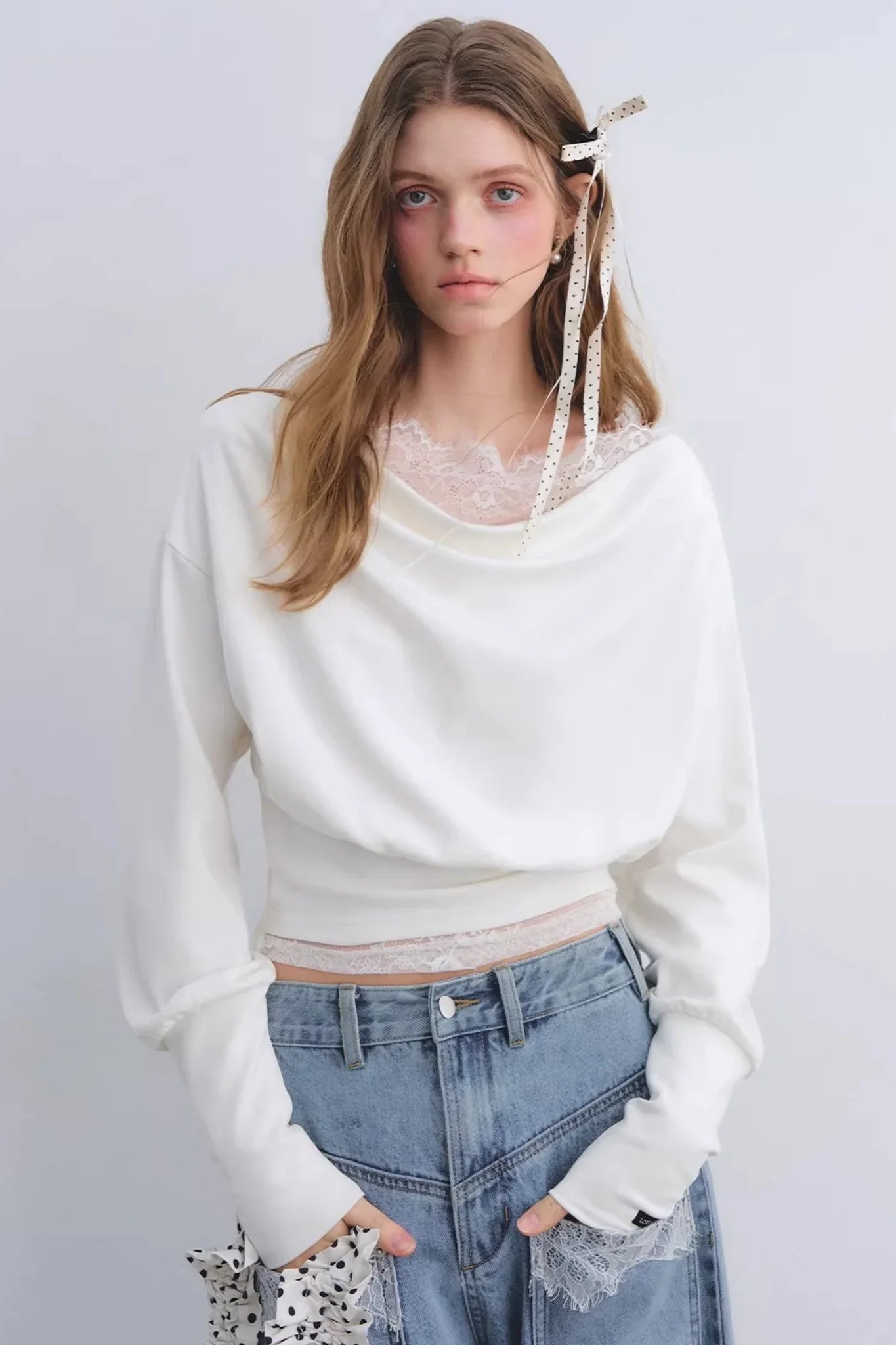 A white off-shoulder top with lace patchwork details.
