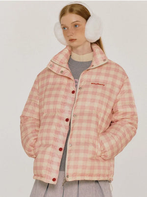 A woman wearing a pink and white plaid puffer jacket with a stand-up collar.