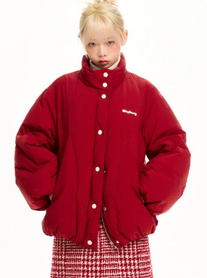 A model wearing a bright red puffer jacket.