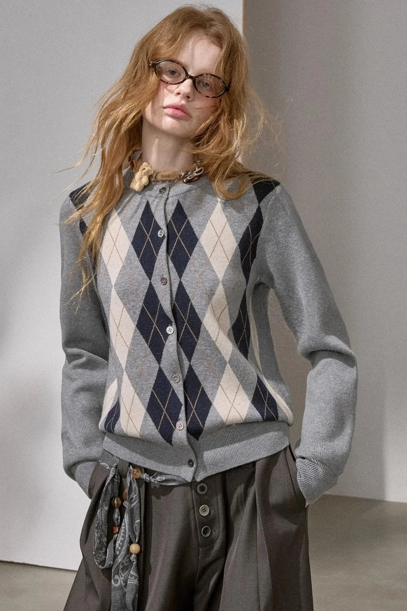 A woman wearing an autumn pear colored diamond-pattern knit top.