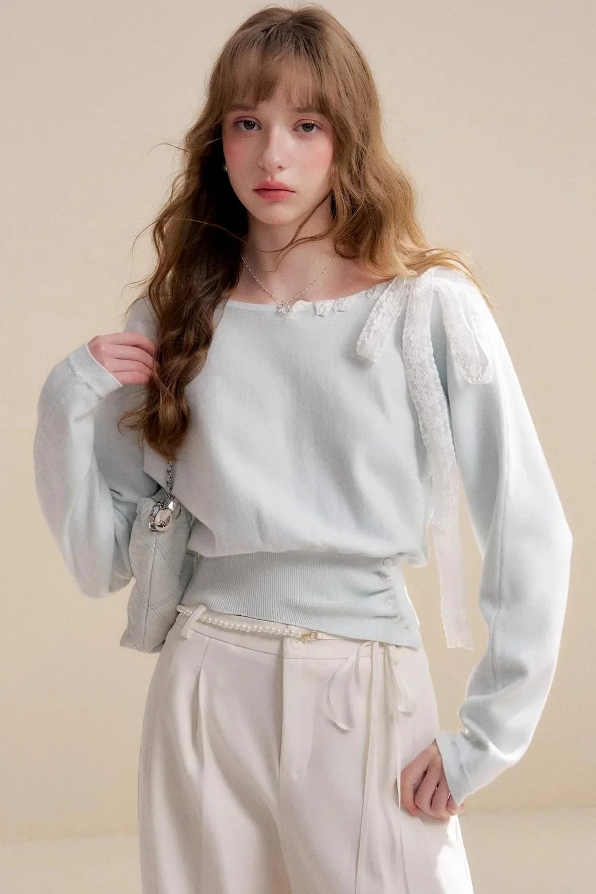 A light mint green off-shoulder knit sweater with delicate lace trim.