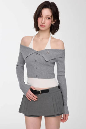 A model wearing a gray and white off-shoulder knit top.