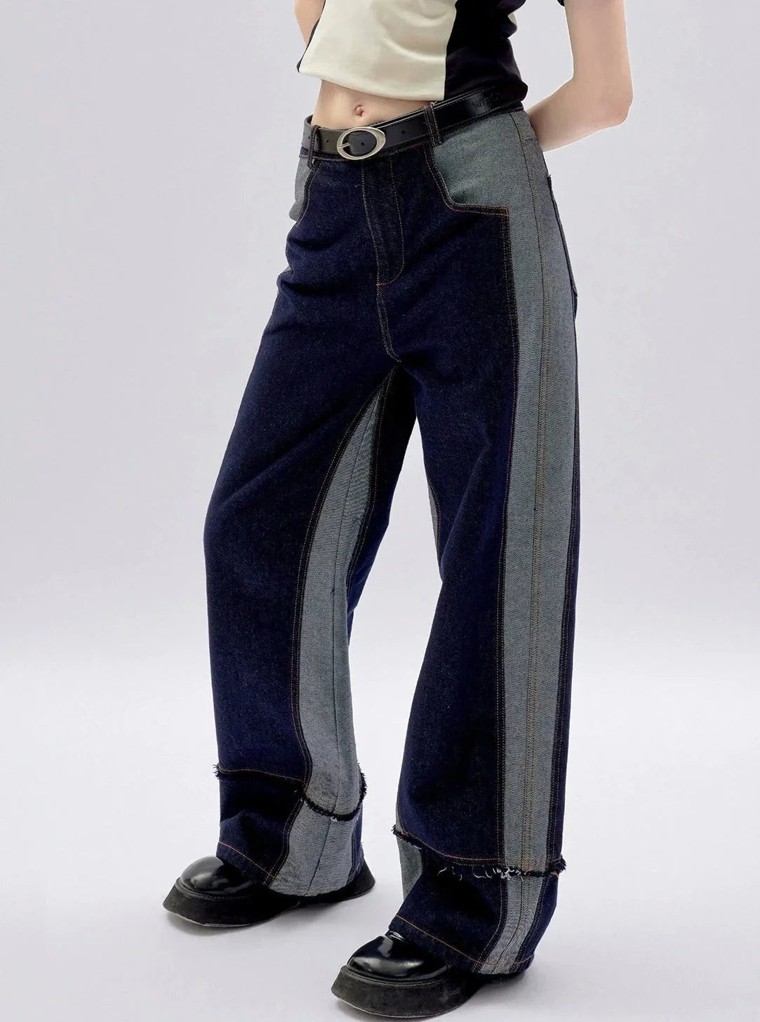 A person wearing two-tone blue wide-leg denim pants.